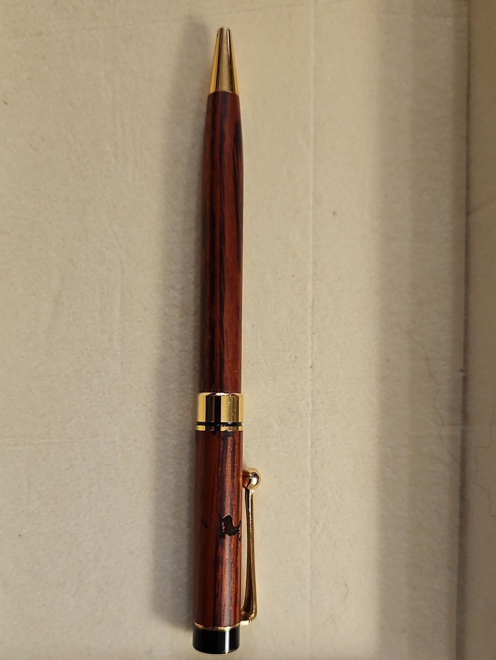 WOOD GRAIN TWIST SLIM LINE STYLE BALLPOINT PEN WITH GOLD TRIM AND A BUCK ON IT